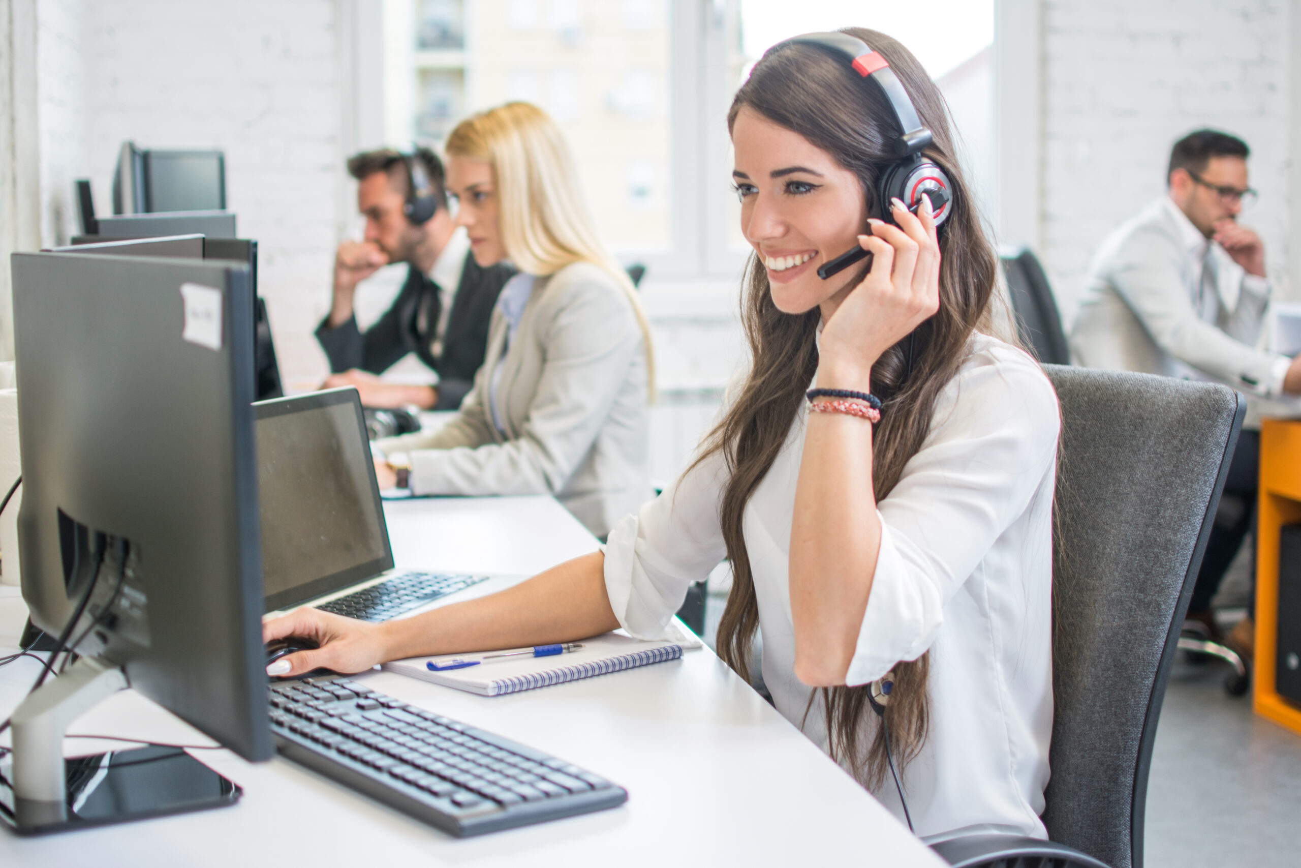 Friendly,Smiling,Woman,Call,Center,Operator,With,Headset,Using,Computer Friendly,Smiling,Woman,Call,Center,Operator,With,Headset,Using,Computer